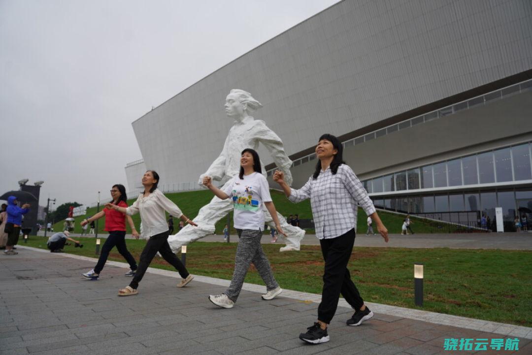 几位观众摆出与广东省美术馆新馆的雕塑雷同的举措，合照纪念。