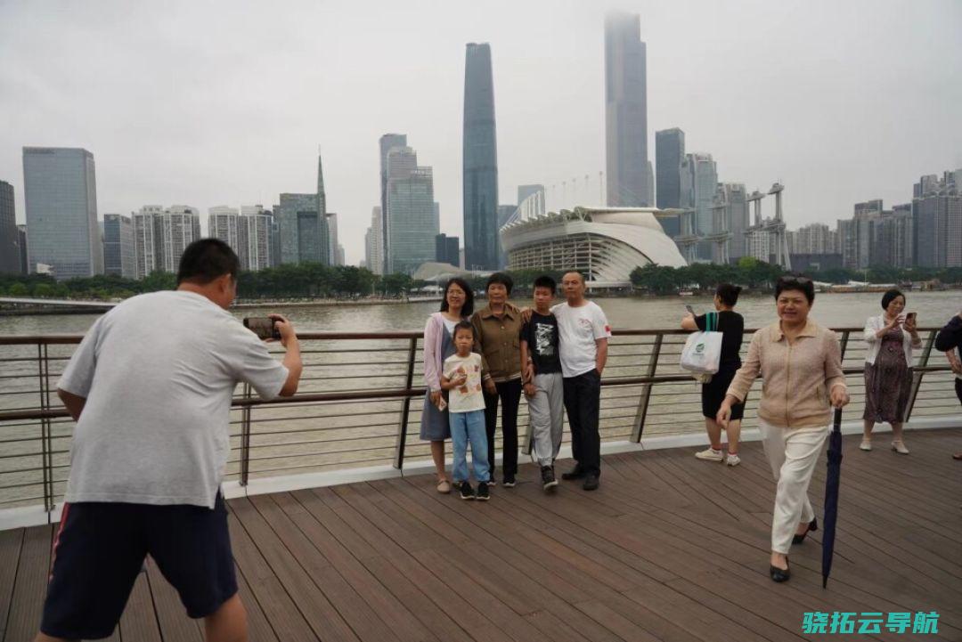 2024年5月1日，“五一”假期首日，市民游客站在海心桥上，以珠江新城和海心沙市区景色为背景拍照“打卡”。