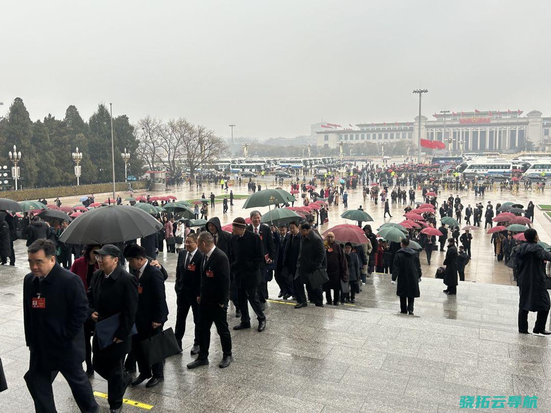 2024年3月5日，十四届人大二次会议召开，图为代表冒雨进入会场。（南边周末记者韩谦/图）